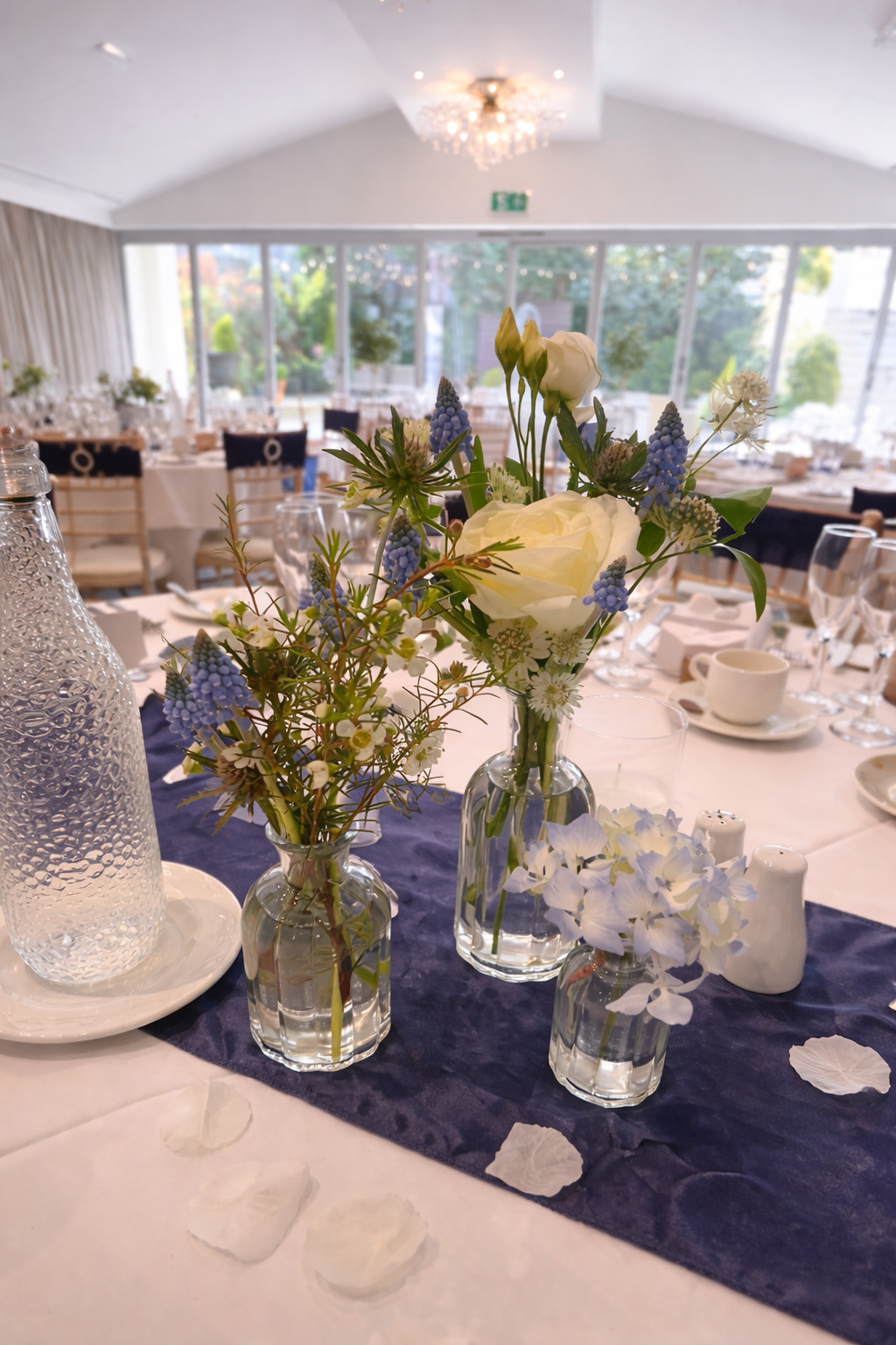 Blue and white table styling with delicate bud vases and velvet runner