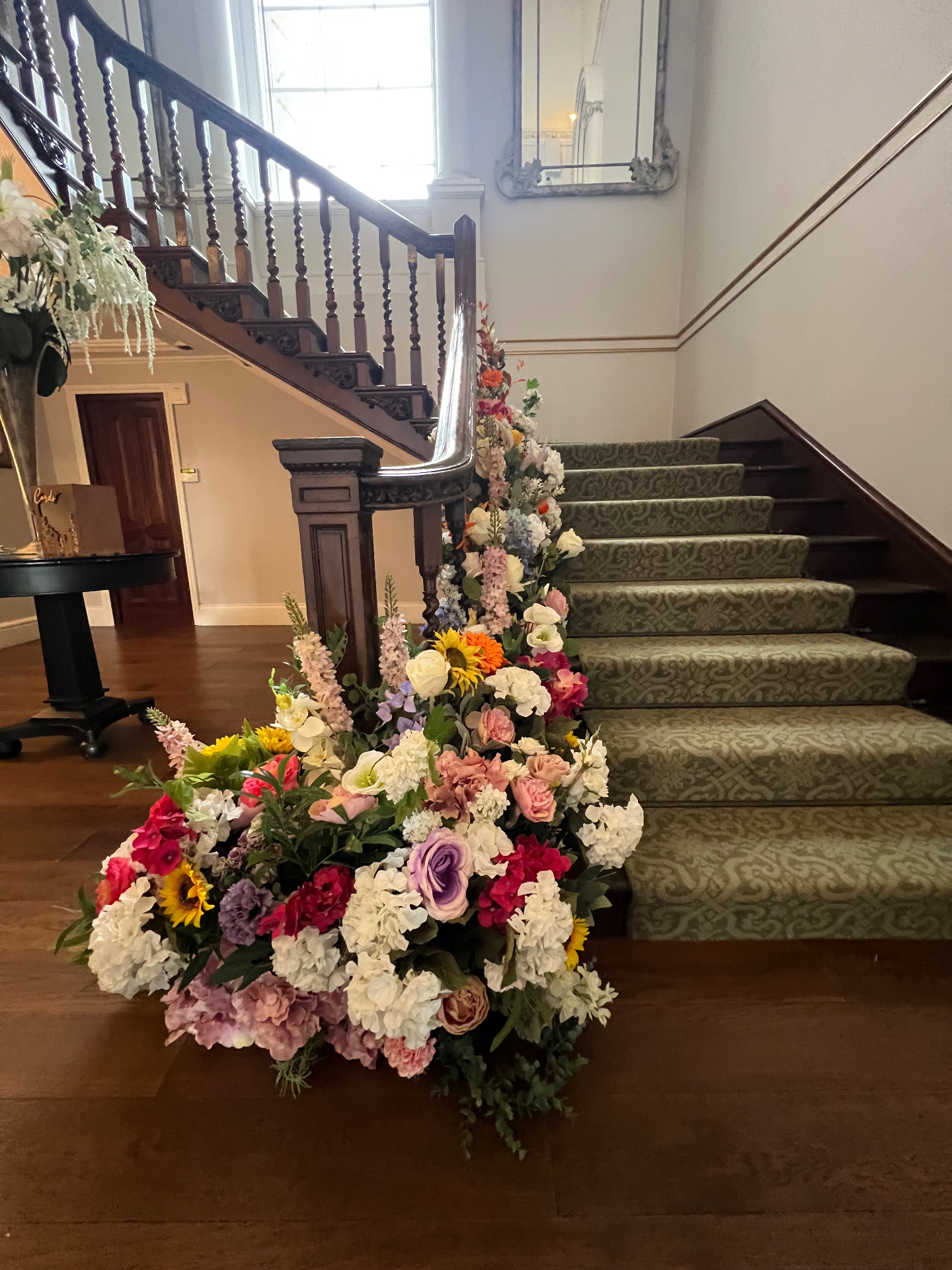 Statement staircase floral installation in soft pastel and bright seasonal tones