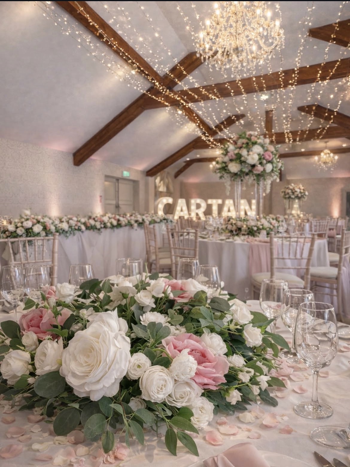 Cartan top table with blush florals and fairy-lit beams