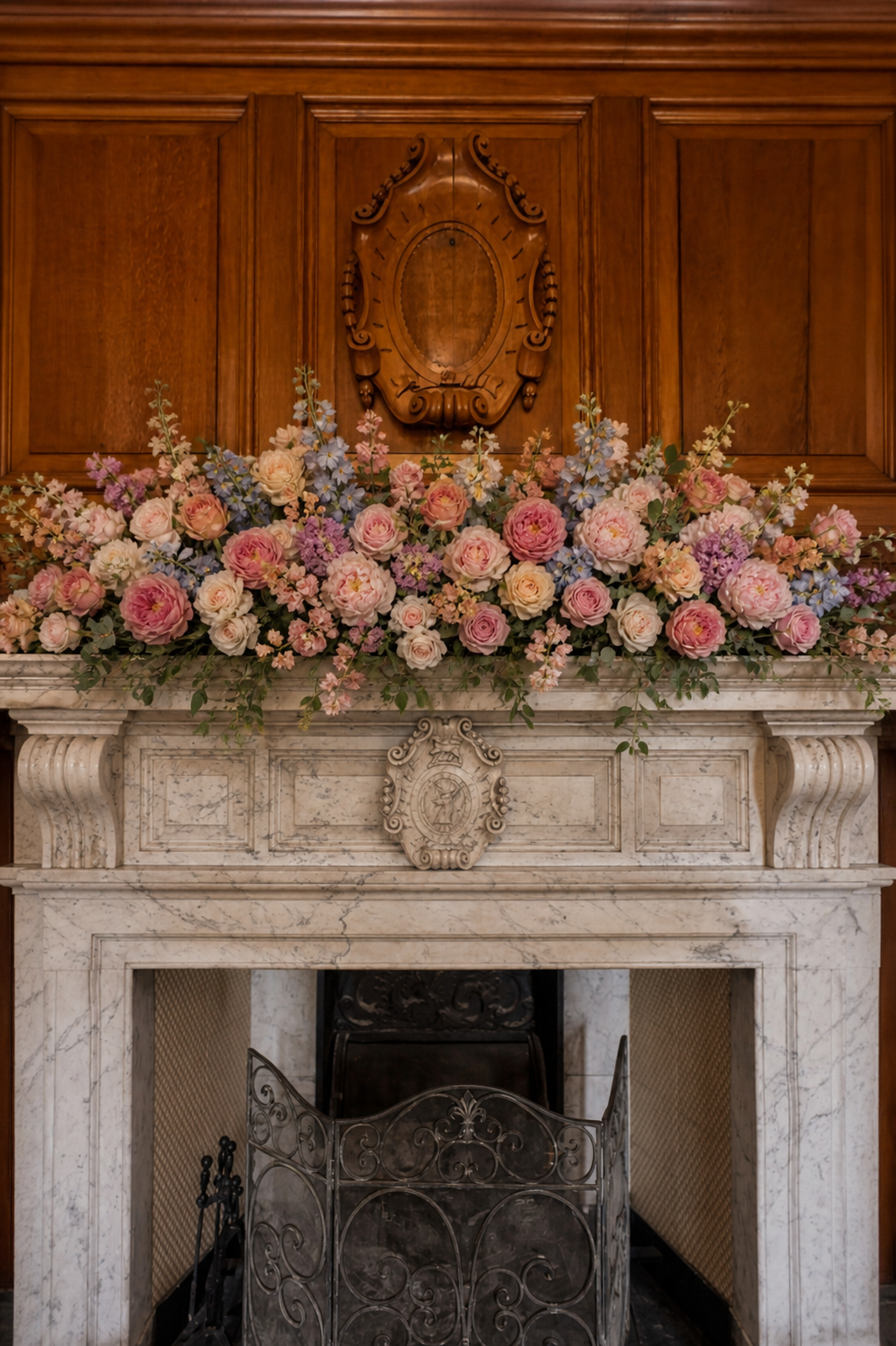 Fireplace mantel dressed with romantic pastel florals and soft garden texture