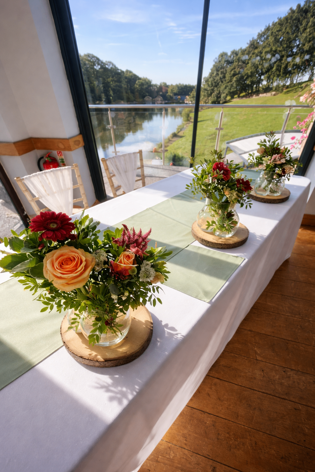 Lakeside top table styled with sage runners and rustic bud vase florals on wood slices