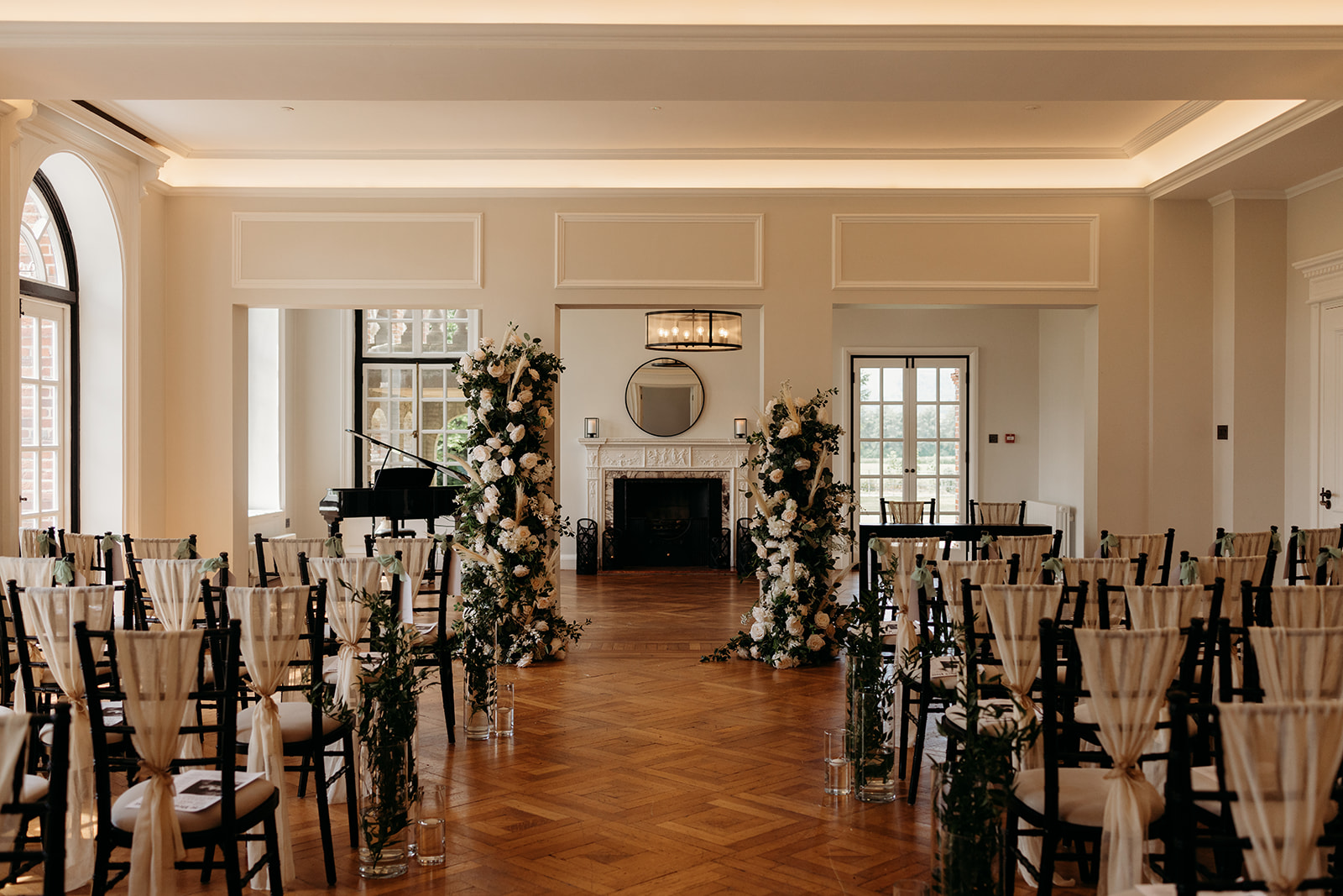 Classic ceremony room with twin floral pillars framing an ornate fireplace