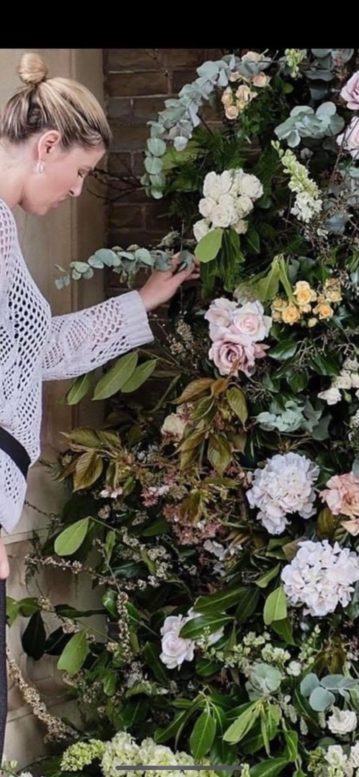 Adele, owner of Rolfes Wedding Styling, arranging a floral installation